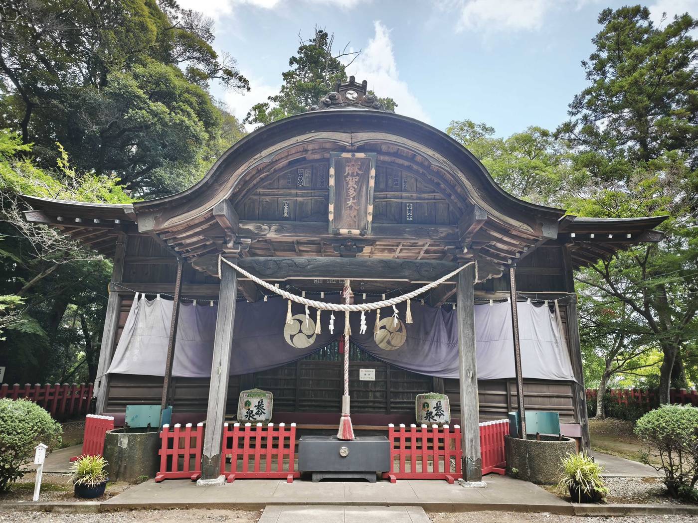 紫の幕がかかった拝殿。三つ巴の紋が並んでいる